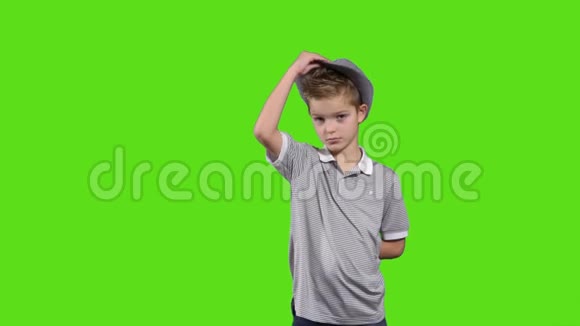 可爱的小孩摘下帽子在绿色背景下欢迎视频的预览图