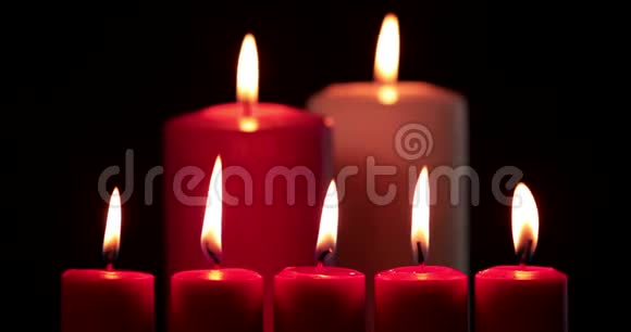 红色圣诞蜡烛在黑暗的背景下燃烧视频的预览图