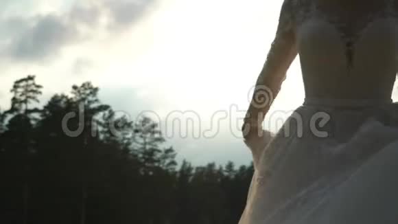 美丽的金发新娘在海边散步视频的预览图