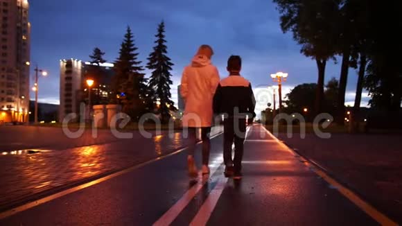 夜雨后散步的年轻女子和男孩视频的预览图