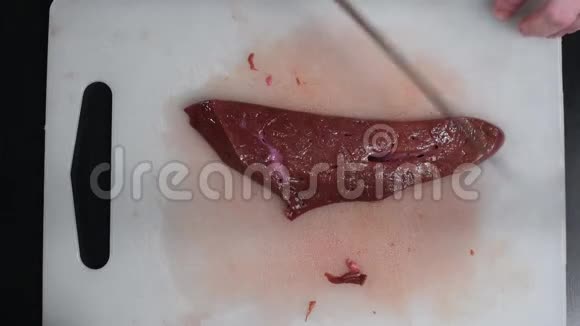 桌上的牛肉肝用一把刀切在白色的切割板上视频的预览图