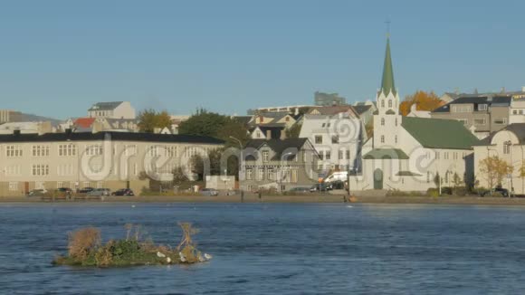 在晴朗的秋日雷克雅未克Tjornin湖附近的古老传统建筑景观视频的预览图