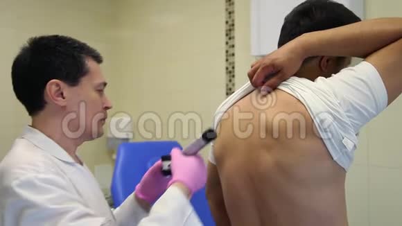 一位男医生用医疗电子设备检查病人皮肤视频的预览图