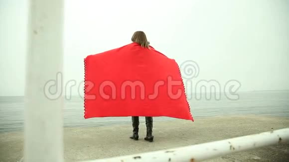 穿着红毯子的沉思的女人望着大海视频的预览图