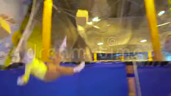 爸爸把儿子扔进蹦床中心的泡沫橡胶坑里视频的预览图