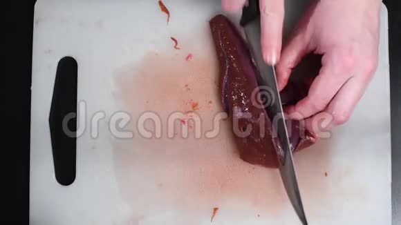 桌上的牛肉肝用一把刀切在白色切割板上视频的预览图