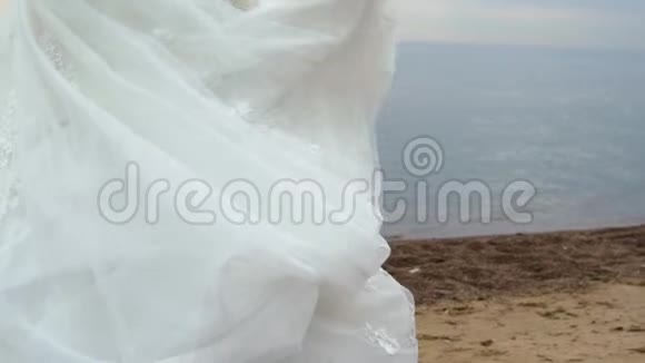 美丽的金发新娘在海边散步视频的预览图
