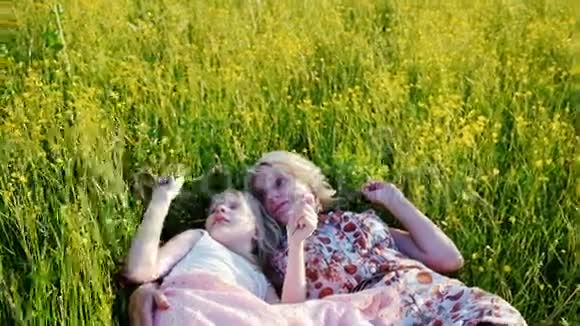 妈妈和女儿6岁的时候一起在一片高大的草地上交流友好幸福的家庭视频的预览图