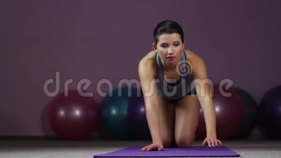 年轻女性做膝盖俯卧撑彻底工作以达到适合身体的目标视频的预览图