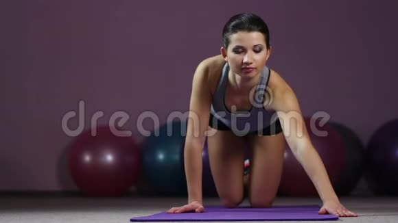积极的漂亮女人做膝盖俯卧撑脸上微笑健身房锻炼视频的预览图