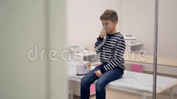 小男孩坐在医院里吸气他脸上戴着吸入面罩视频的预览图