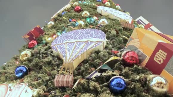 巨大的圣诞树装饰着五颜六色的球花环和雪中礼物视频的预览图
