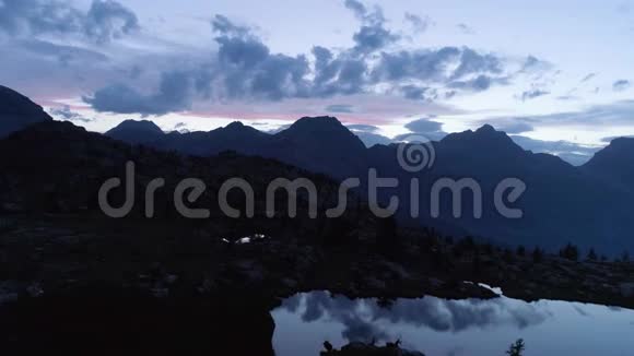 在夜晚的夏日在清澈的蓝色湖泊和松树林之上前进欧洲意大利阿尔卑斯山山谷奥斯塔户外绿色视频的预览图