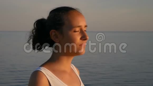 慢动作一个美丽的女孩在大海的背景上微笑视频的预览图