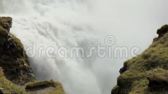 在两块岩石之间快速流动的强大瀑布覆盖着苔藓史诗般的景色视频的预览图