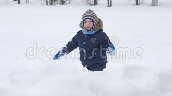 可爱的小男孩和年轻的母亲在冬天和公园里的雪玩耍蓝色的孩子夹克和红色的妈妈视频的预览图