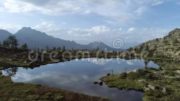 在日落的夏日在清澈的蓝色湖泊和松树林之上向前迈进欧洲意大利阿尔卑斯山山谷奥斯塔户外绿色视频的预览图