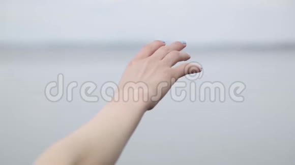 女人的手在触摸湖底的空气视频的预览图
