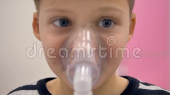 男孩通过吸入器呼吸脸上的面具特写视频的预览图