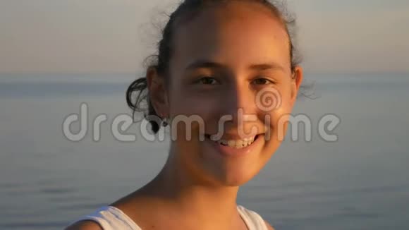一个美丽的女孩在大海的背景上微笑视频的预览图