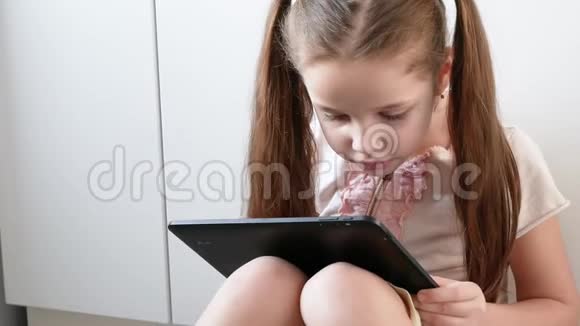 情绪化的女孩正在用平板电脑玩电子游戏儿童电子小玩意画像视频的预览图