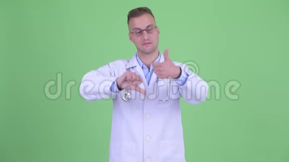 困惑的男医生在拇指向上和拇指向下之间做出选择视频的预览图