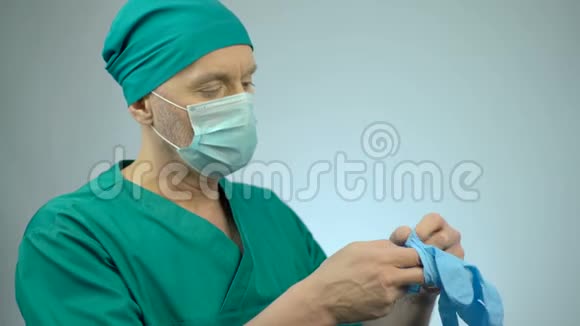 紧张的外科医生戴上医用手套为严重的手术做准备视频的预览图