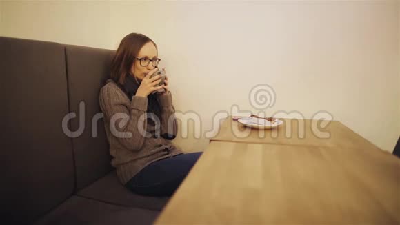 美丽迷人的年轻女子戴着眼镜在咖啡馆喝咖啡或茶好心情她笑了晚上的时间视频的预览图