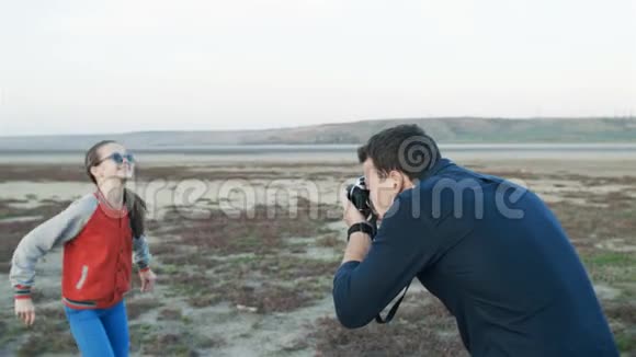 父亲在大自然中给他的小女儿拍照女孩蹦蹦跳跳视频的预览图
