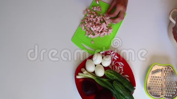一个女人正在切香肠盘子旁边是蔬菜汤煮甜菜洋葱和其他原料视频的预览图