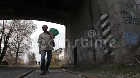 在桥下散步的失业男子视频的预览图