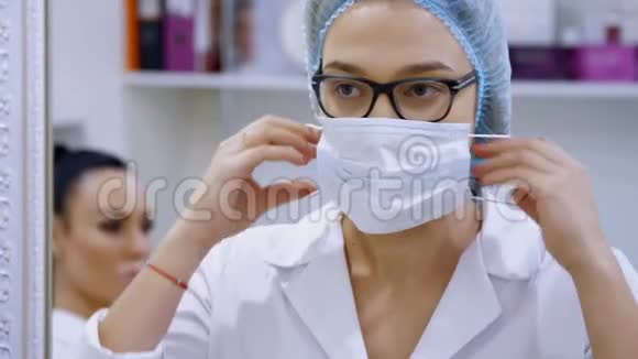 诊所的美容室里一位女医生戴着眼镜穿着白色制服戴着医疗帽视频的预览图