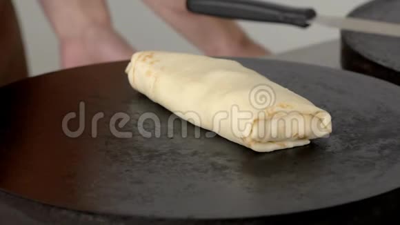 刷子慢慢地在盘子上涂抹一块准备好的煎饼视频的预览图