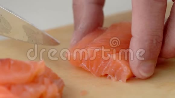 寿司师傅在餐馆里慢动作地把一条鲑鱼切成碎片视频的预览图
