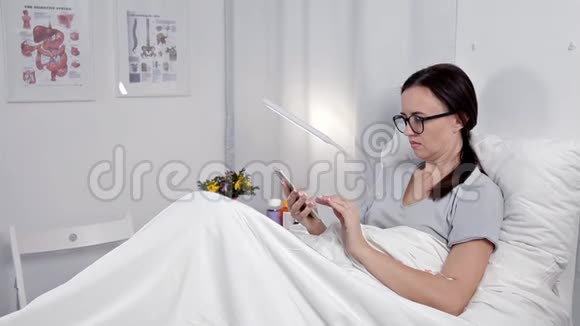 医院病床上使用移动电话的女性病人视频的预览图