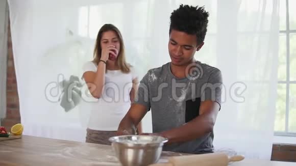 漂亮的非洲人在木桌上准备面团他的女朋友要来了给他苹果但拿着视频的预览图