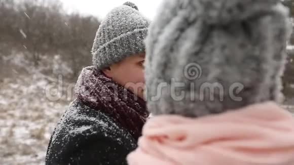 户外冬林拍摄的年轻新婚夫妇散步微笑和说话在雪天气松林期间视频的预览图