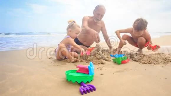 孩子们爷爷在沙滩上用海浪冲浪建造沙堡视频的预览图