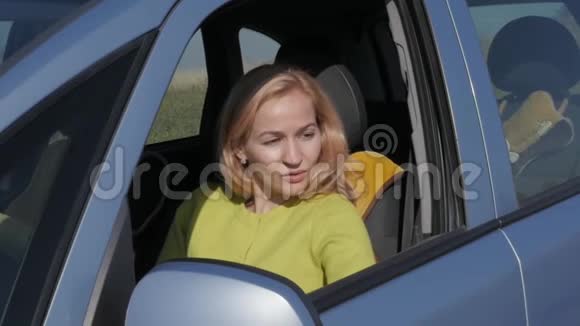 自信的年轻女人在汽车的车轮上喝咖啡慢动作视频的预览图