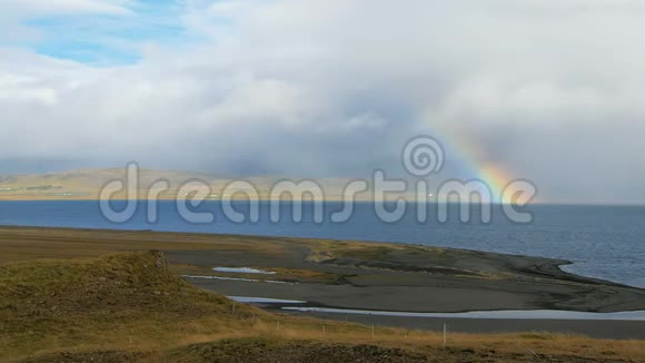 在晴朗的日子里美丽的彩虹在冰岛峡湾上空低雨的云彩和阳光视频的预览图