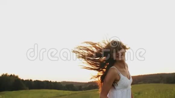 日落时分花束跑在田野上的快乐女孩在阳光下的草地上尽情享受视频的预览图