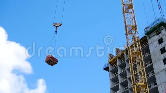 吊车及建筑施工现场顶着蓝天重荷挂在起重机吊钩上的构造视频的预览图