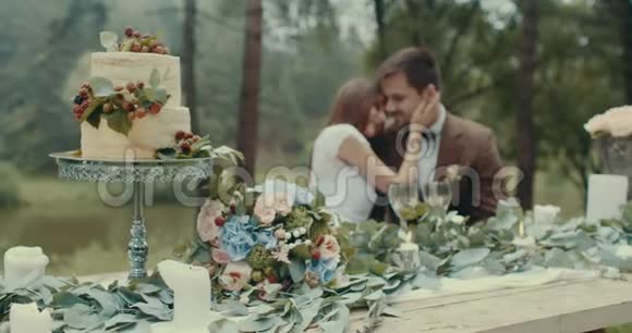浪漫的约会组合美味的蛋糕和餐桌上的一束鲜花上面装饰着树叶和蜡烛视频的预览图