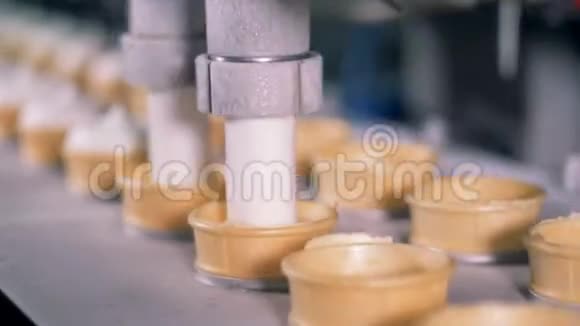 工厂用冰淇淋填充晶片杯的快速运动过程视频的预览图