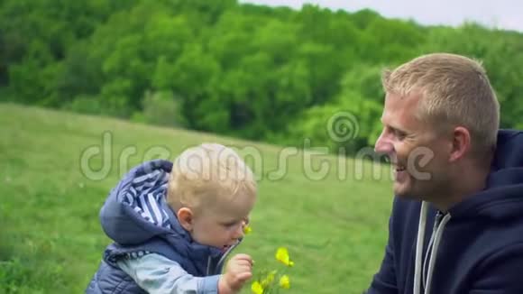 年轻快乐的父亲在公园和小儿子玩耍视频的预览图