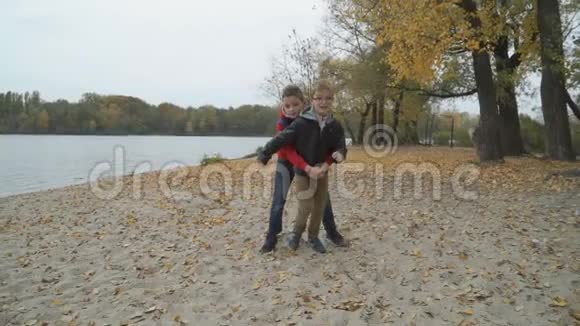 两兄弟在秋天的海滩上玩得开心视频的预览图