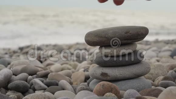 在海滩上手工搭建一堆石头视频的预览图