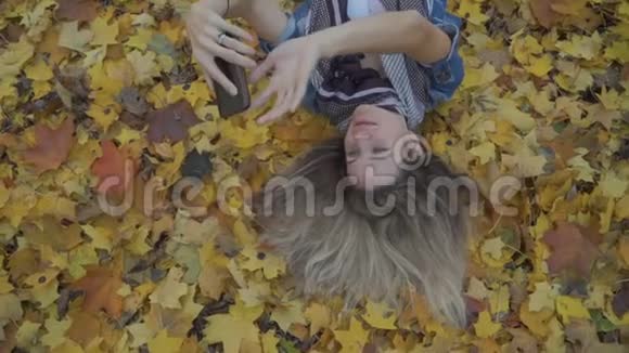 女人自拍照躺在秋叶上视频的预览图