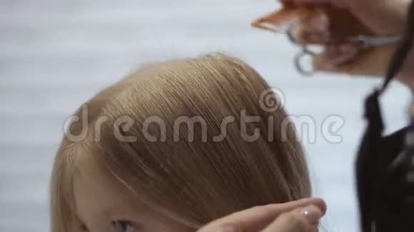 发型师理发师在美容院为一个可爱的小女孩做发型美发理发视频的预览图