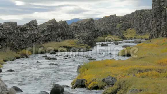暗玄武岩之间流淌着小河的壮丽景色秋日多云视频的预览图